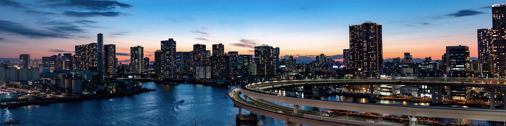 Skyline ville crépuscule, route courbe sur rivière.