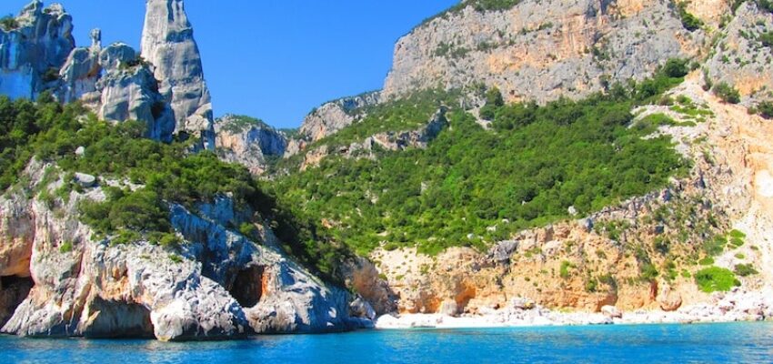 Alghero Fertilia : falaises, végétation, mer bleue.
