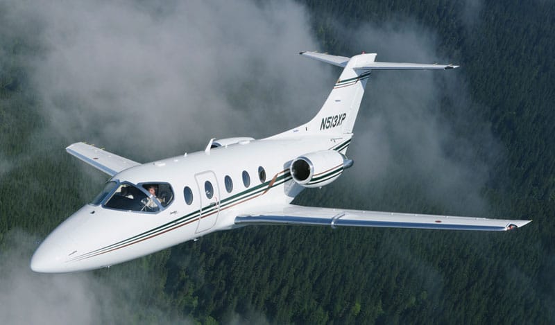 **Texte alternatif:**  
Location de jet privé, BEECHJET 400 survole une forêt.