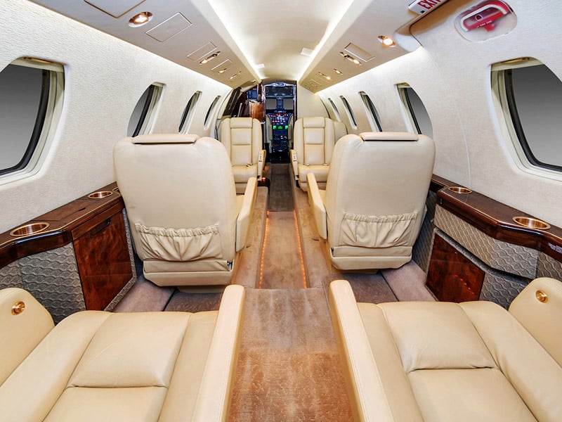 **location de jet privé** Luxueux intérieur beige avec accents bois.