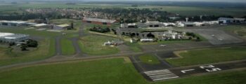 Jet privé : chemin verdoyant menant à un bâtiment blanc.