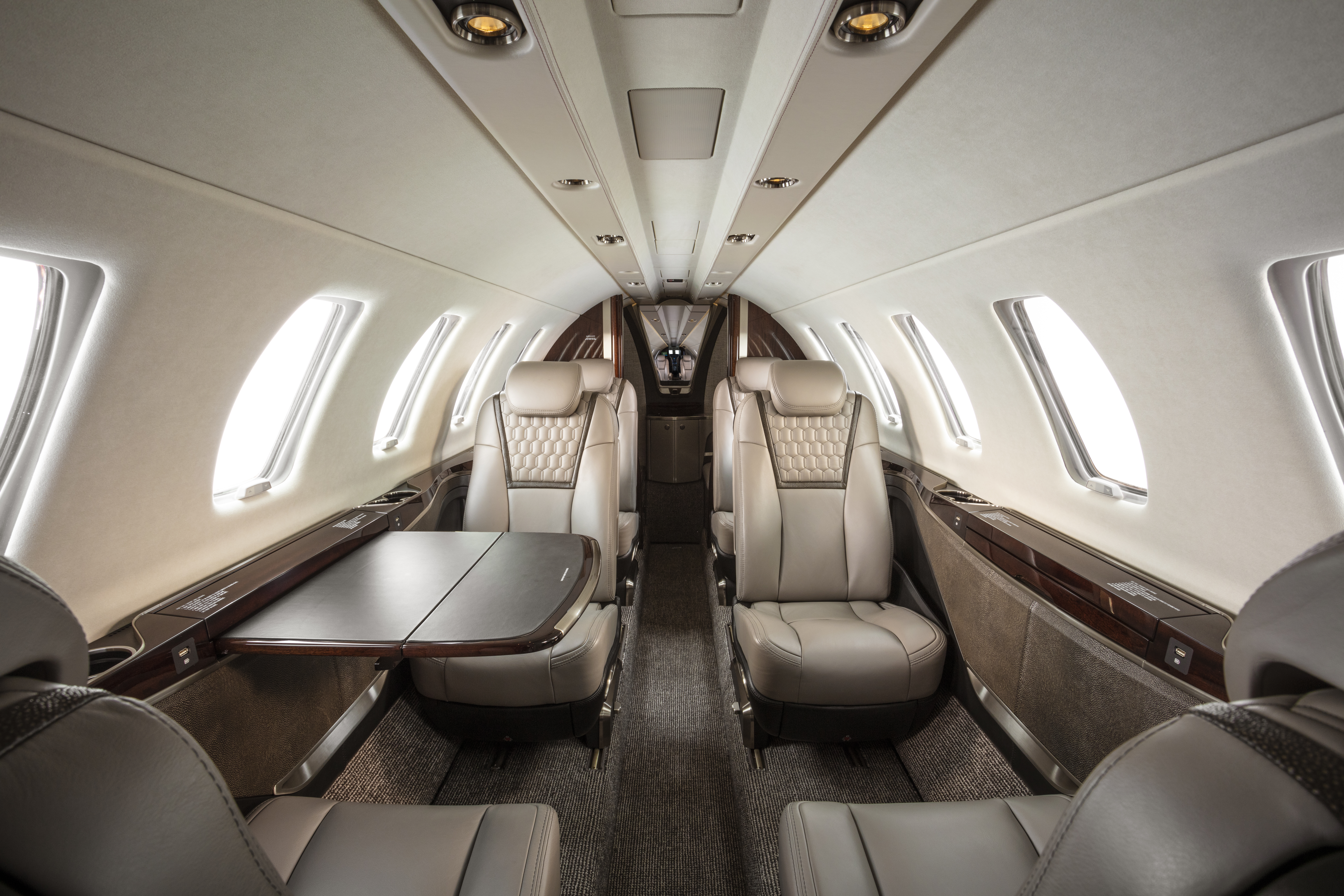 CJ4 Gen 2 intérieur - sièges luxe, table, bois.